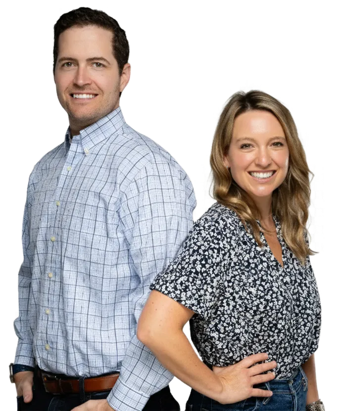 A professional male and female real estate team standing together and smiling.
